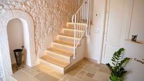 A staircase with white railings, a stone wall, and a potted plant. - Prima Stella - Campanile Inn 
Comfortable room in historic building -Locorotondo (Locorotondo)