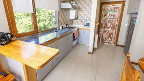 A kitchen with a wooden countertop, a stove, a microwave, and a door labeled "SALIDA". - Modern and quiet apartment minutes from downtown Bariloche (San Carlos de Bariloche)