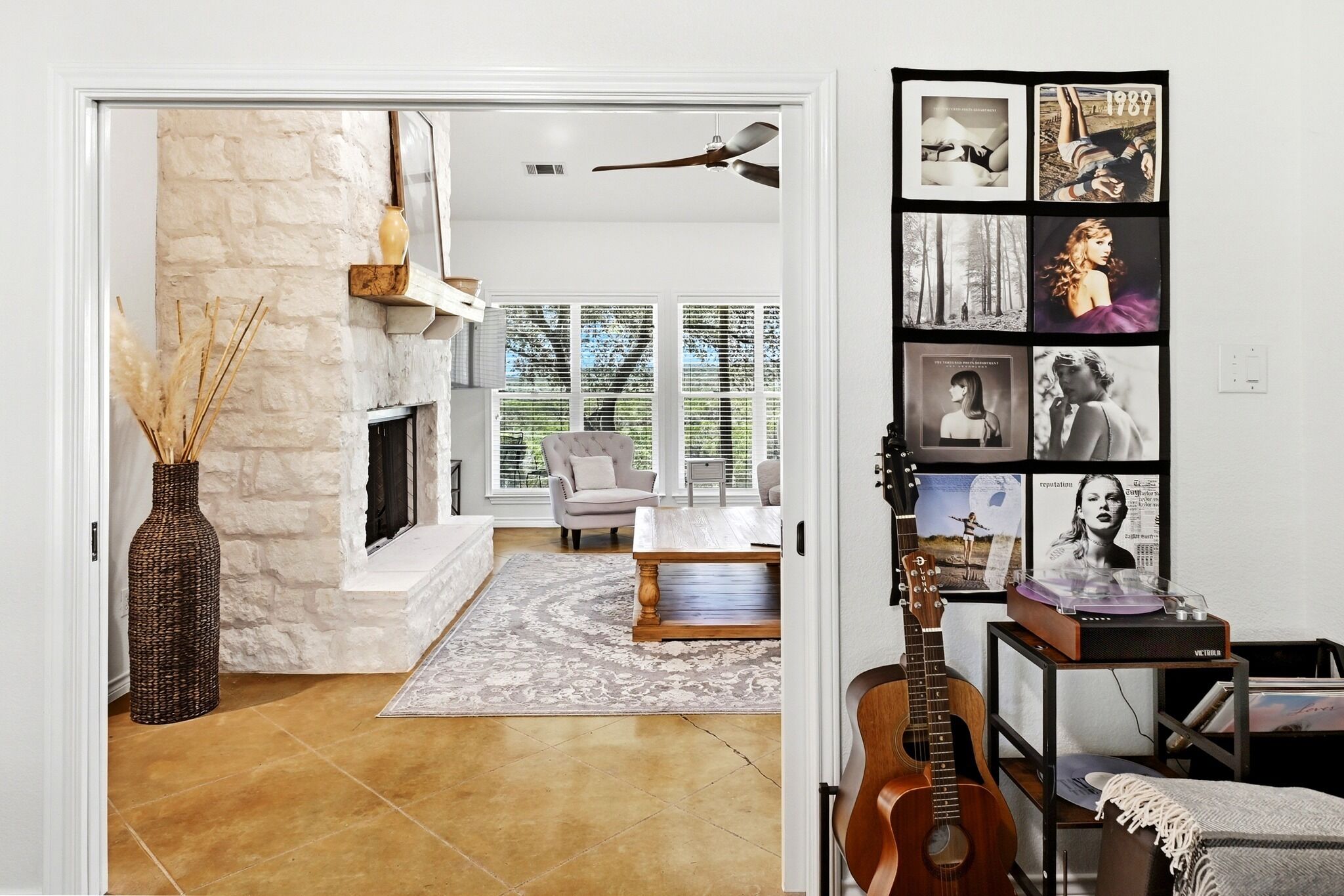 A living room with a fireplace, a sofa, a coffee table, and a guitar.