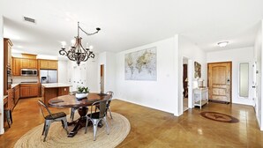 Uma cozinha ampla com eletrodomésticos modernos, uma área de jantar com mesa redonda e um grande mapa-múndi na parede.