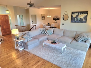 Ein Wohnzimmer mit Ecksofa, Couchtisch, Lampe und Teppich.