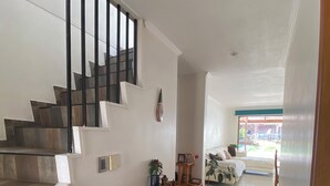 A staircase with a black railing leading to a bedroom with a bed and a window. - Comfortable and spacious house in Chicureo (Chicureo)