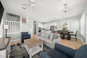 A modern living room with a sofa, coffee table, and a staircase with a 'Relax' sign.
