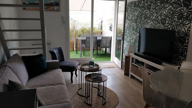 A modern living room with a sofa, chairs, a coffee table, and a TV. - Cosy quiet house 4 persons, parking & bikes, Royan  (Royan)