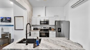 A modern kitchen with white cabinets, stainless steel appliances, and a marble countertop. - Brand-New on the OTR Streetcar Line (Cincinnati)