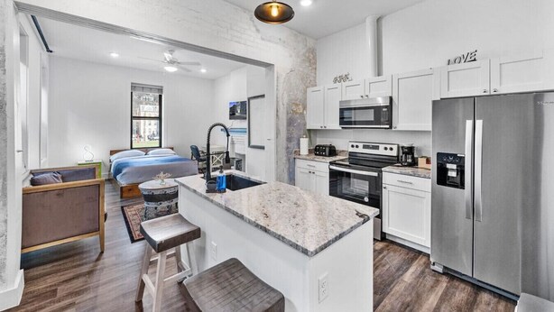 A modern kitchen with white cabinets, stainless steel appliances, and a central island. - Brand-New on the OTR Streetcar Line (Cincinnati)