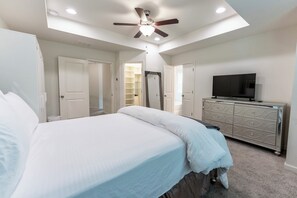 A bedroom with a bed, a ceiling fan, a TV, and a dresser. - 3-bedroom Modern Townhome in charming Lithonia! (Lithonia)