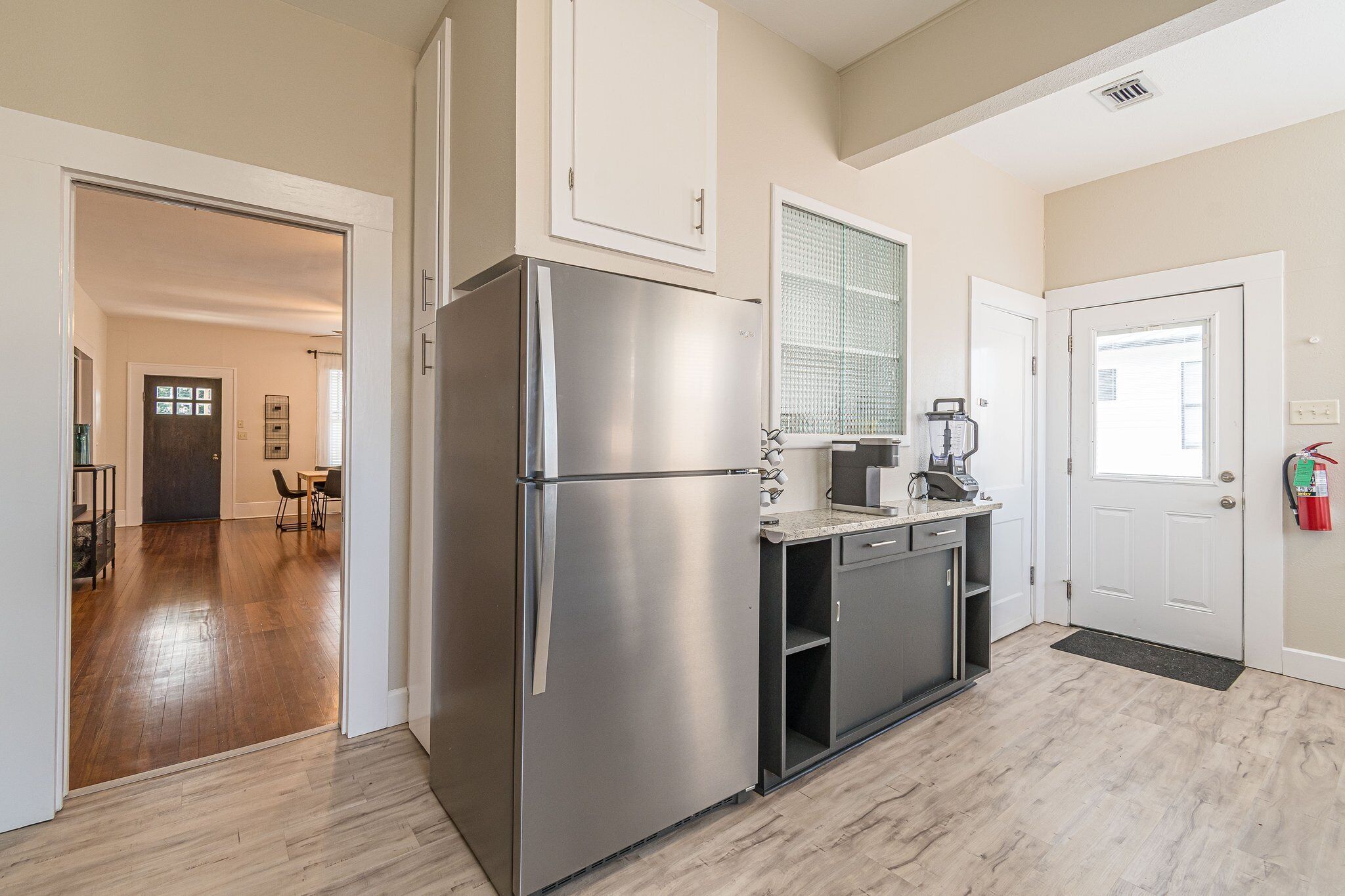 A modern kitchen with a stainless steel refrigerator, a coffee maker, and a microwave.