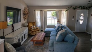Un salon avec un canapé, une table basse, une cheminée et un téléviseur.