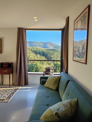 A room with a green sofa, a desk, and a view of a forested mountain. - Writer's retreat, with one of the best views of the Douro Valley! (Raiva)