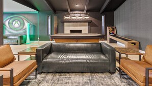 Ein modernes Wohnzimmer mit einer schwarzen Ledersofa, einem Holztisch und einem Kamin.