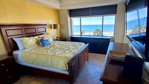 A hotel room with a bed, a TV, and a view of the beach. - Baja 404 Las Palmas Beachfront Resort (Puerto Peñasco)