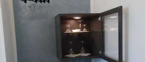 Una habitación compacta con armario empotrado, un refrigerador pequeño y un espejo.