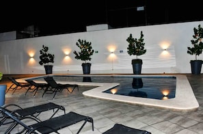 An outdoor pool area with lounge chairs and potted plants. - Condo in Centro histórico de Guadalajara Downtown w/parking and pool (Guadalajara)