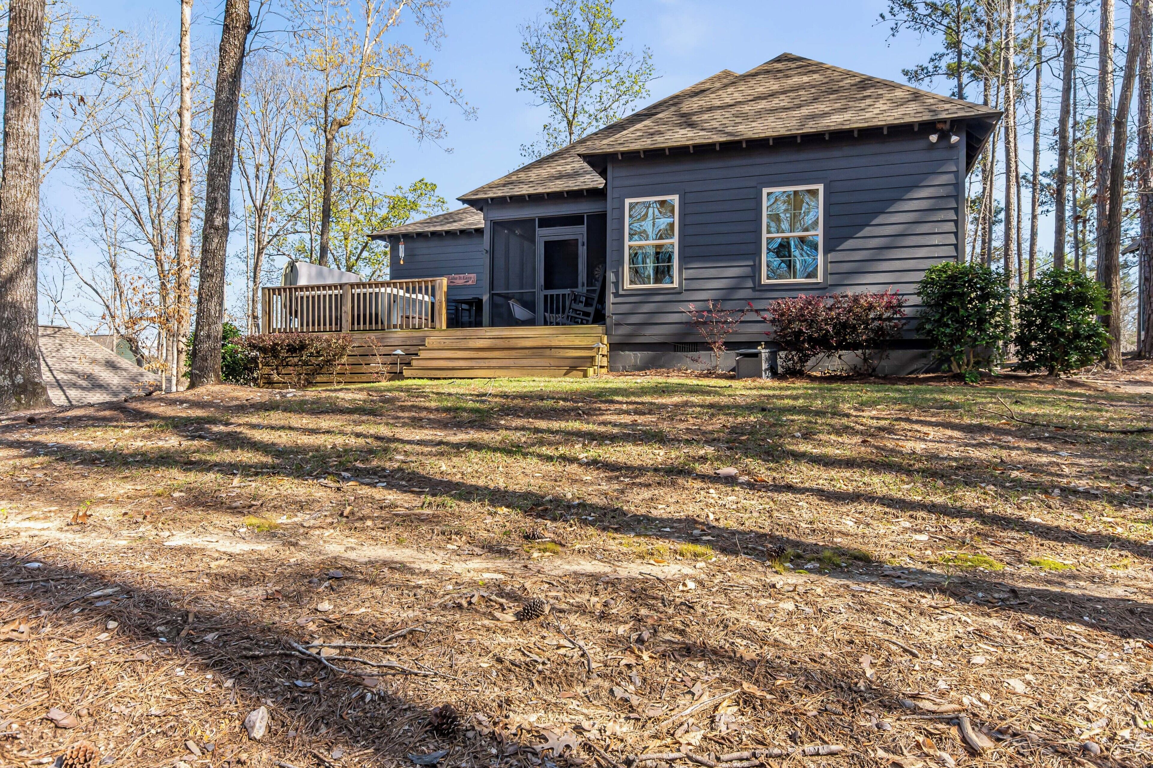 A two-story house with a front porch, a deck, and a small front yard.