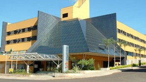 Un bâtiment moderne doté d’une façade géométrique originale, d’une entrée imposante et d’une enseigne indiquant la présence d’un restaurant.