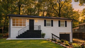 A single-story house with a front entrance, a small front yard, and a garage. - Spacious 3-bedroom home delightful East Atlanta minutes away from downtown (Atlanta)