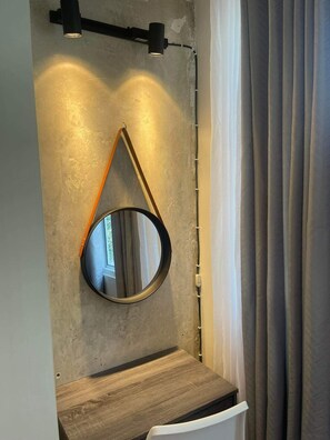 A bathroom with a round mirror, wooden countertop, and a towel rack. - Sea residences near MOA Arena/SMX 2nd floor 1BR by darpm (Pasay City)