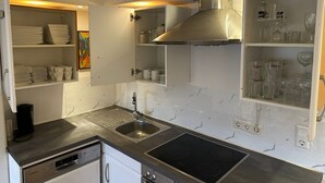 Een moderne keuken met een roestvrijstalen spoelbak, een Bosch vaatwasser en een inbouwfornuis.