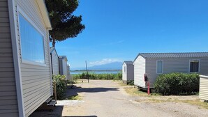 En række campingvogne med grusvej og en klar blå himmel.