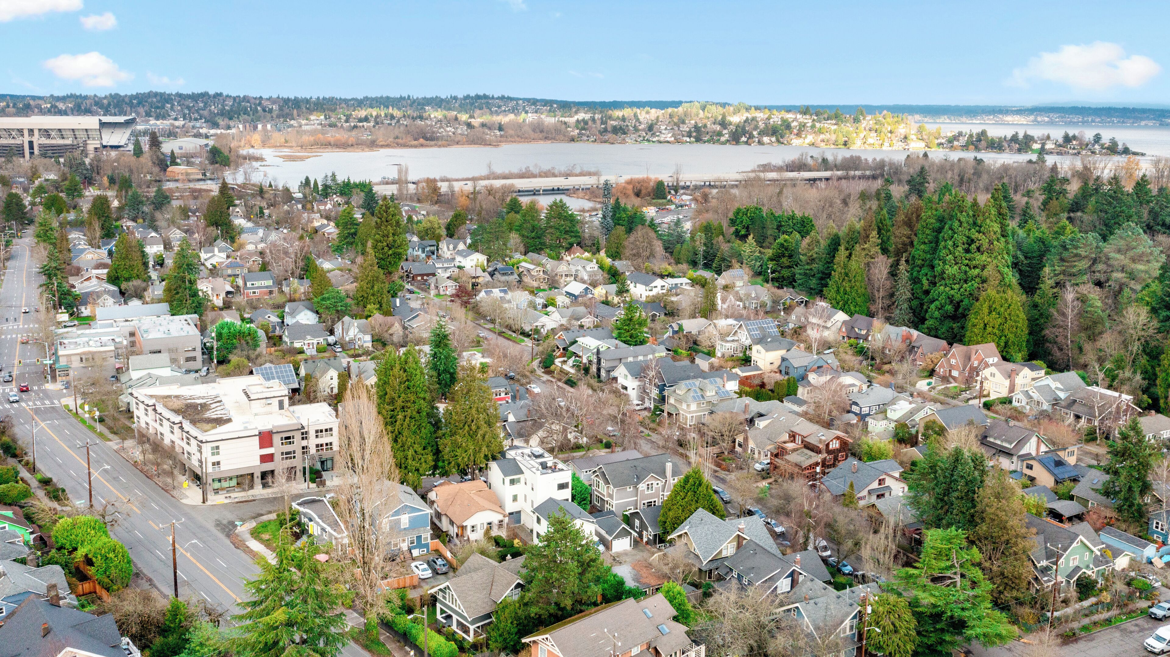 A residential area with houses, roads, and a large body of water in the background.