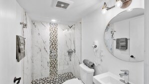 Un baño con inodoro, lavabo y ducha.