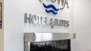 Letrero en la pared del Hotel & Suites Nisswa, con un diseño moderno y un detalle de pared de piedra.