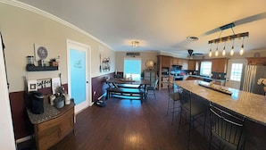 A spacious kitchen with a central island, wooden cabinets, and a bar area. - 3-bedroom home with great  backyard  & pool with a  private and peacful setting (Spring Hill)