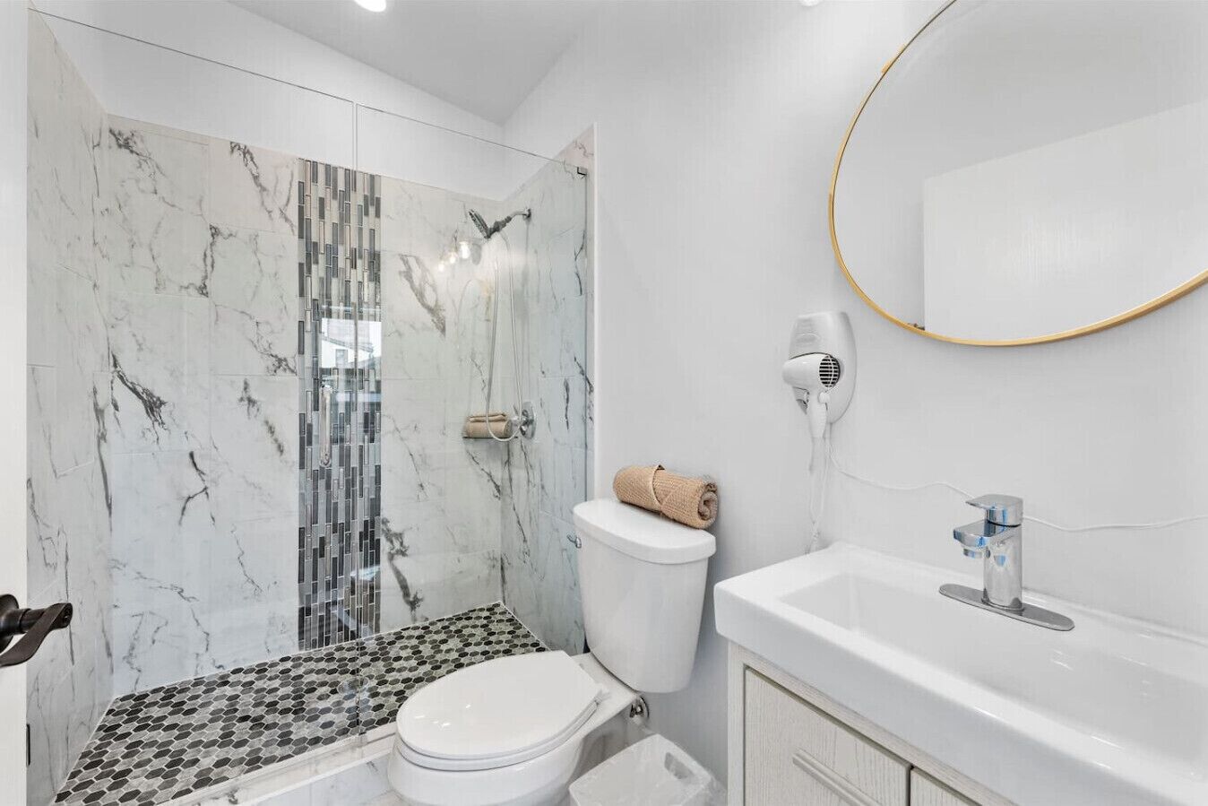 Une salle de bain moderne équipée d’une douche, de toilettes et d’un lavabo.