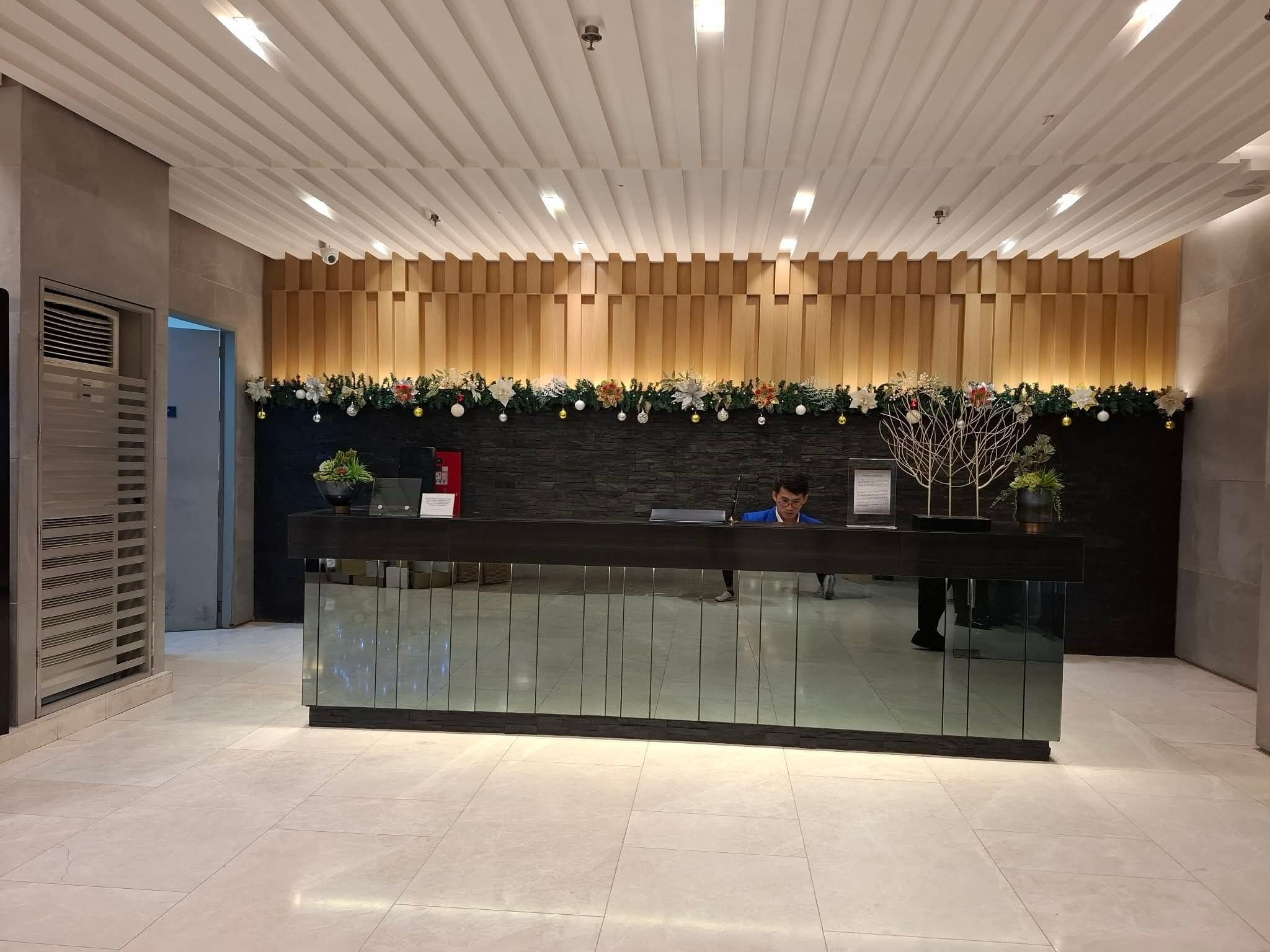 A reception desk with a modern design, featuring a wooden panel wall and a glass counter.