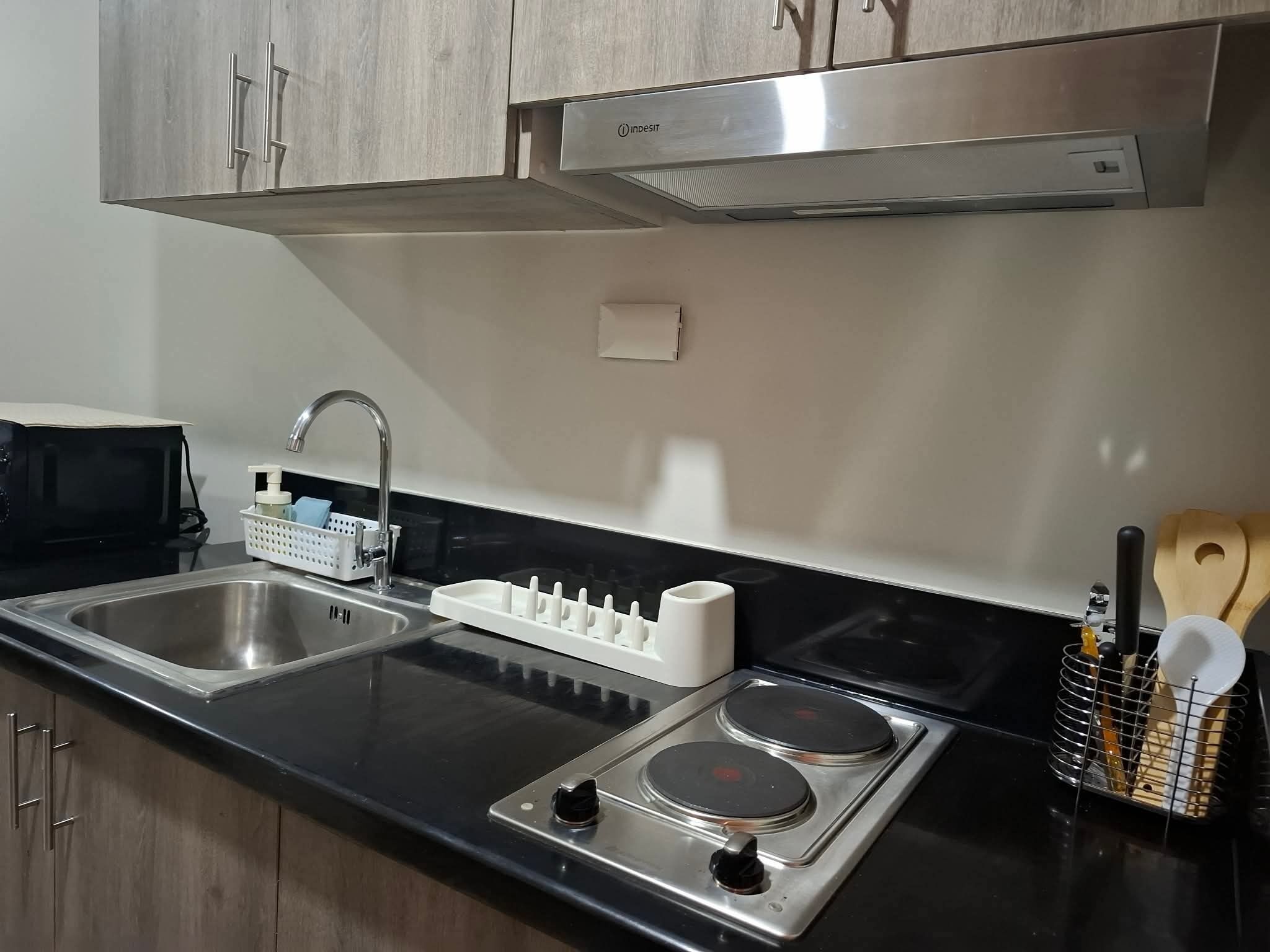 Een moderne keuken met roestvrijstalen apparatuur, een dubbele spoelbak en houten kasten.