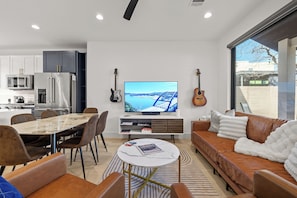 A modern living space with a dining area, kitchen, and seating area. - Downtown - Pool + Family + Deck + FirePit + Pets (Austin)