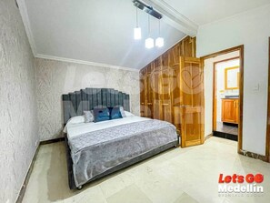 Une chambre à coucher comprenant un lit, une armoire et une porte donnant sur une salle de bain.
