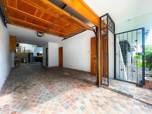 A spacious interior with a tiled floor, a wooden ceiling, and a metal gate.
