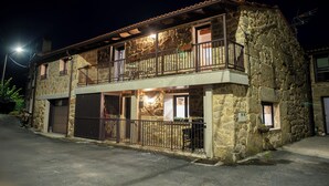 A stone building with a balcony, a garage, and a small window. - Complete 4 Bedroom House near Termas de Bande and Lobios - Villa Limia (Chaos)