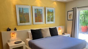 A bedroom with a bed, bedside tables, and artwork on the wall. - Spacious 2 Bed, 2 Bath Apartments - 10 Minute Walk to Beach, Dining & Shopping (La Manzanilla del mar municipio de la Huerta)