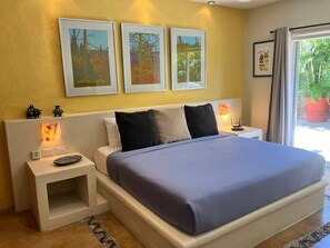 Ein Schlafzimmer mit einem Bett, Nachttischen und Bildern an der Wand.