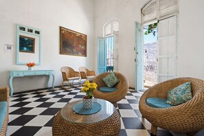 A room with a checkered floor, wicker furniture, a blue console table, and a painting on the wall. - Casa Mary - Beautiful 5BR House in the Old City (Cartagena de Indias)