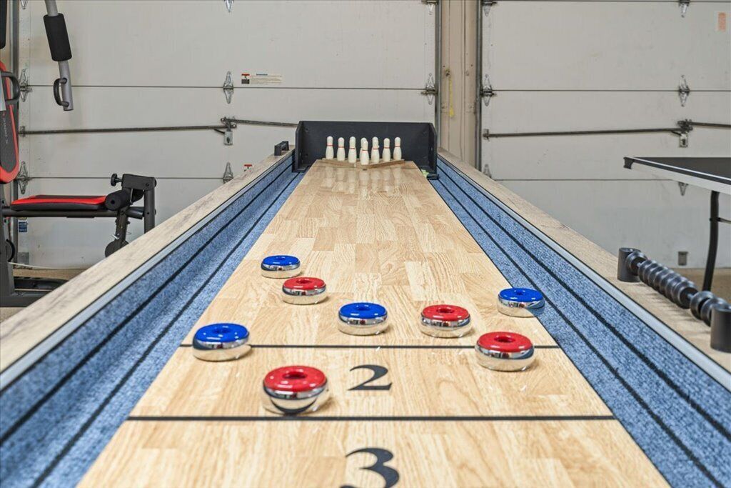 A shuffleboard table with numbered scoring areas and pucks.