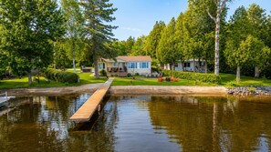 A lakeside property with a dock, a house, and a well-maintained lawn. - Chalet Café & Complicité. Warm and Cozy! Lakeside, Spa, and Foyer, Weedon (Weedon)