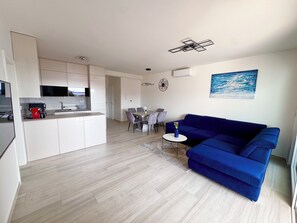 A modern apartment with a kitchen, dining area, and living room. - Ruhige 4★ Ferienwohnung mit Meerblick – 90m zum Strand, Zaboric bei Sibenik (Žaborić)