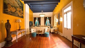 A spacious living room with a wooden floor, a sofa set, a dining table, and a chandelier. - View Carrie de Maison - 1 block to French Quarter (New Orleans)
