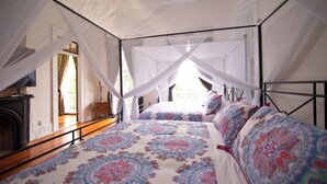 A bedroom with a canopy bed, a wooden floor, and a view of the outdoors. - View Carrie de Maison - 1 block to French Quarter (New Orleans)