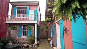 A courtyard with a balcony, potted plants, and outdoor furniture. - View Carrie de Maison - 1 block to French Quarter (New Orleans)