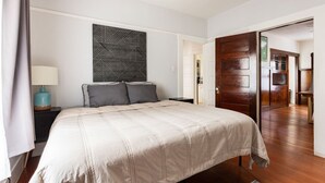 A bedroom with a large bed, a nightstand, a lamp, and a geometric wall art piece. - Craftsman 2 blocks from Russian River Brewery! (Santa Rosa)