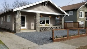 A two-story house with a stone foundation, a front porch, and a fenced yard. - Craftsman 2 blocks from Russian River Brewery! (Santa Rosa)