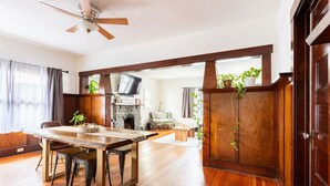 A spacious living area with a wooden dining table, chairs, and a fireplace. - Craftsman 2 blocks from Russian River Brewery! (Santa Rosa)