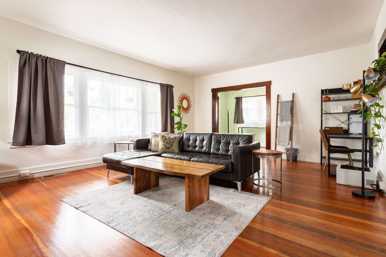 Un salon moderne avec un canapé en cuir, une table basse en bois et une bibliothèque.