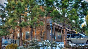A building with a sign reading "924 Incline Way," surrounded by trees and snow.
