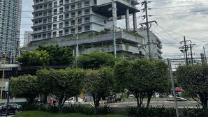 Um edifício de vários andares com design arquitetônico moderno, com varandas e telhado plano.